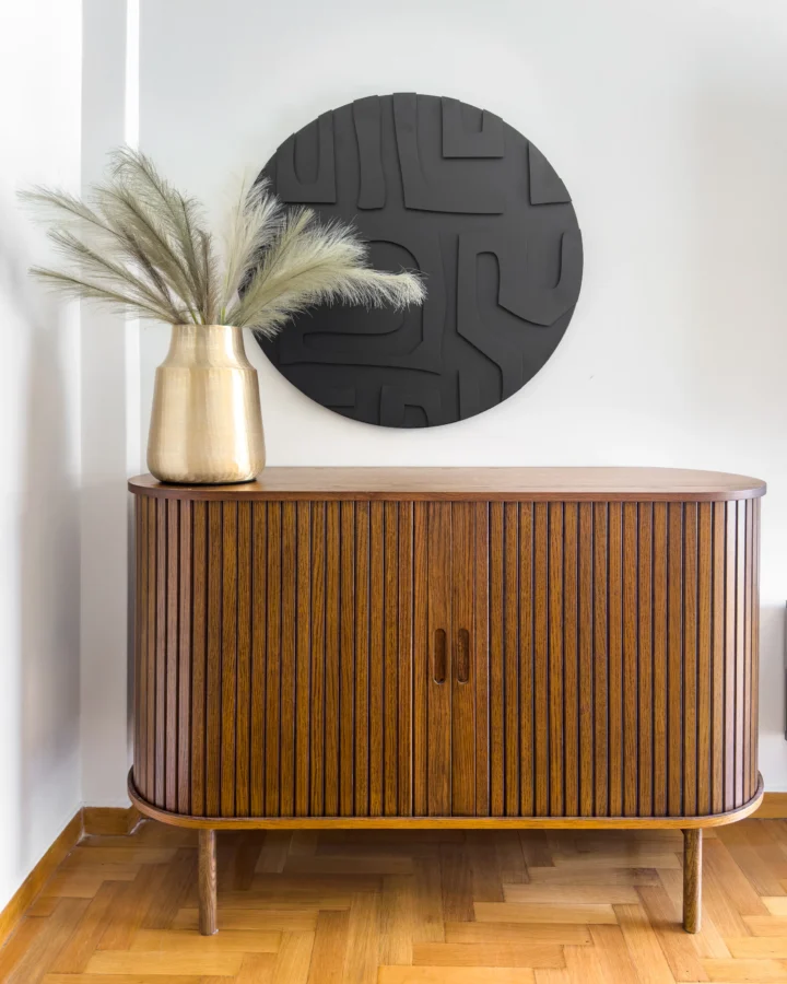 Ribbed wooden sideboard and round black artwork, Timeless Kallisto, Koukaki – IDYLI Architects